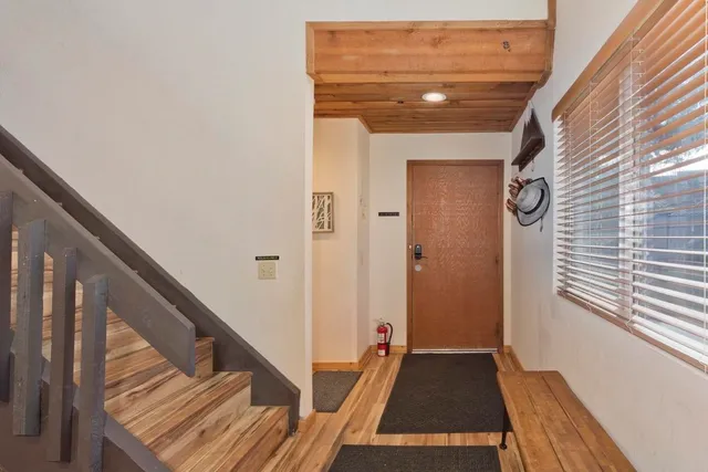 a view of a hallway with wooden floor and staircase