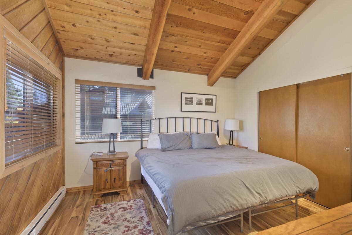 175 Mammoth Slopes Drive, Unit 3 Mammoth Lakes, CA 93546 - Photo 20 of 30 a spacious bedroom with a bed a table and chair