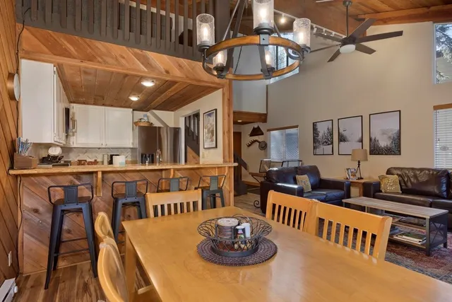 a open kitchen with stainless steel appliances kitchen island granite countertop a table and chairs