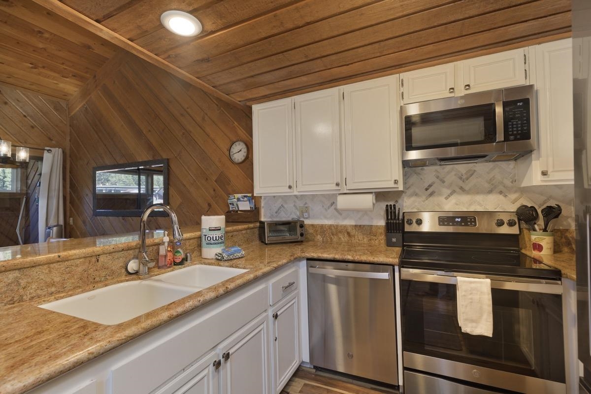 175 Mammoth Slopes Drive, Unit 3 Mammoth Lakes, CA 93546 - Photo 8 of 30 a kitchen with stainless steel appliances a stove a sink and white cabinets