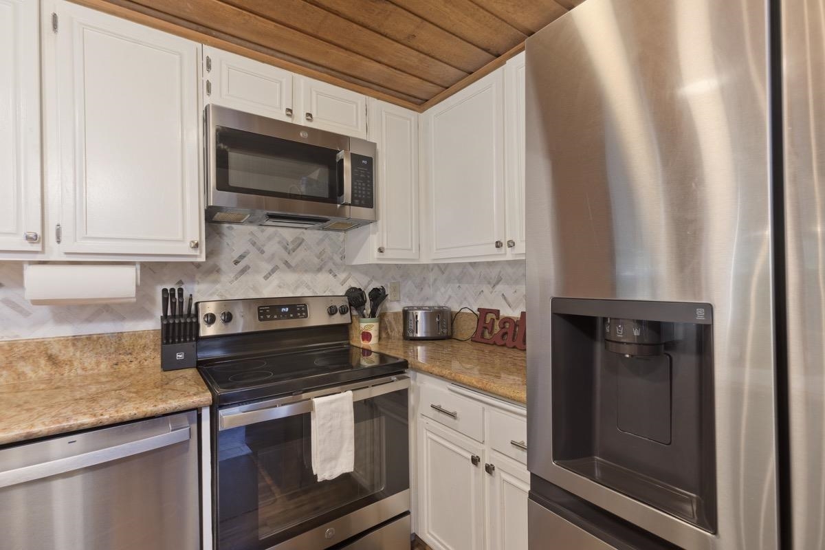 175 Mammoth Slopes Drive, Unit 3 Mammoth Lakes, CA 93546 - Photo 9 of 30 a kitchen with stainless steel appliances granite countertop a stove microwave and sink