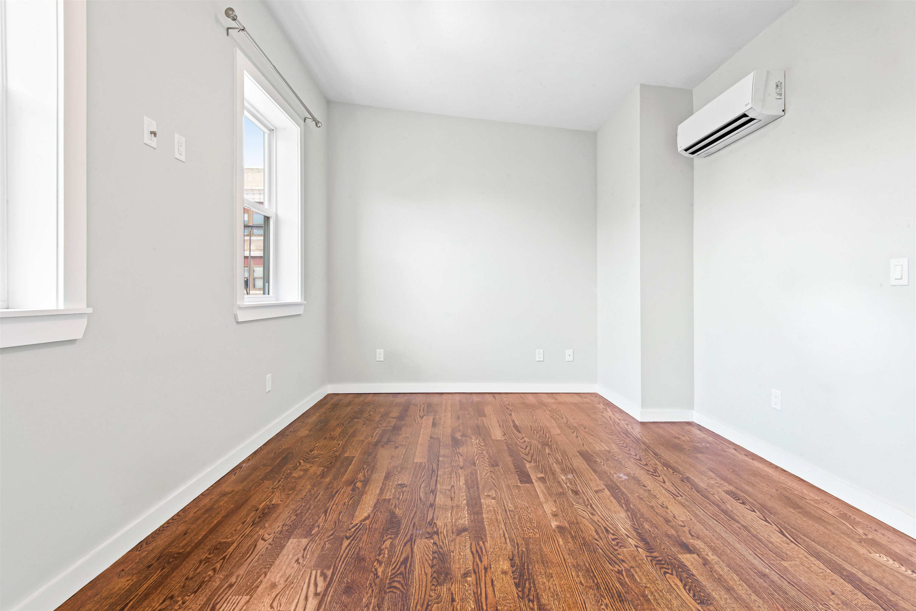 102 Colgate Street, Unit 302 Jersey City, NJ 07302 - Photo 16 of 21 an empty room with wooden floor and windows