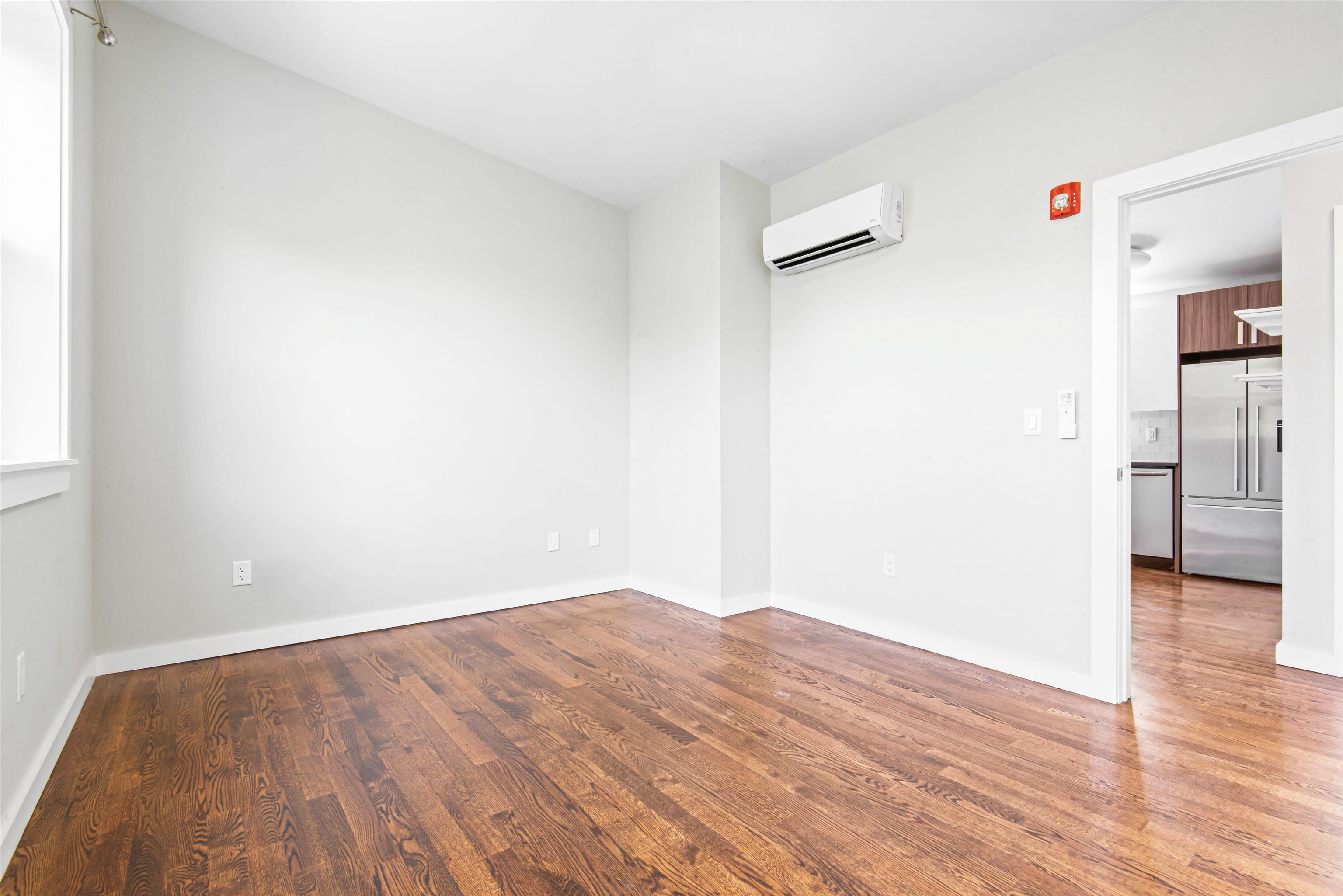 102 Colgate Street, Unit 302 Jersey City, NJ 07302 - Photo 17 of 21 a view of a big room with wooden floor and a refrigerator