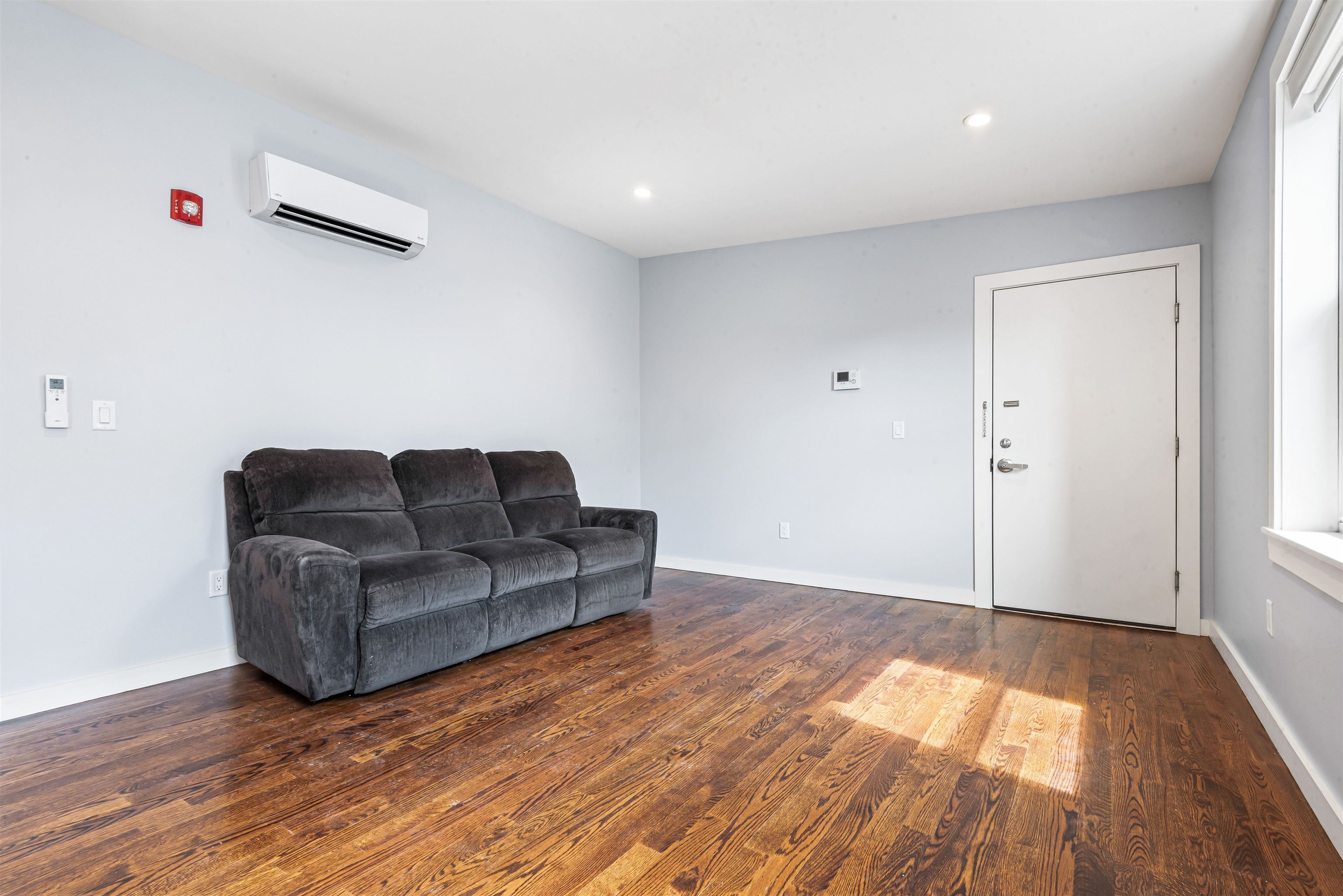 102 Colgate Street, Unit 302 Jersey City, NJ 07302 - Photo 20 of 21 a living room with furniture and a wooden floor