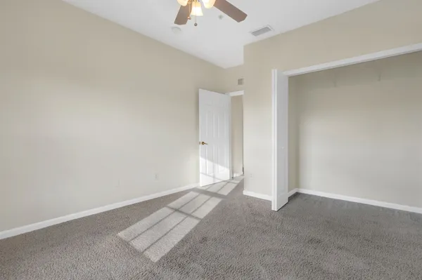 an empty room with chandelier fan