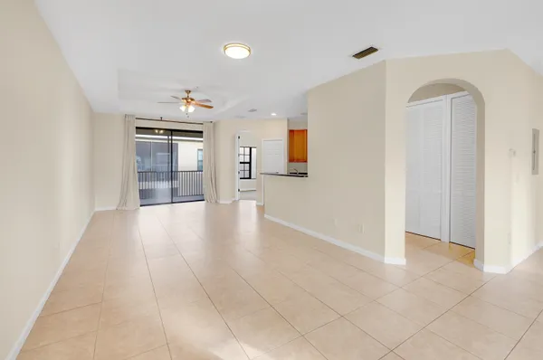 an empty room with kitchen and windows