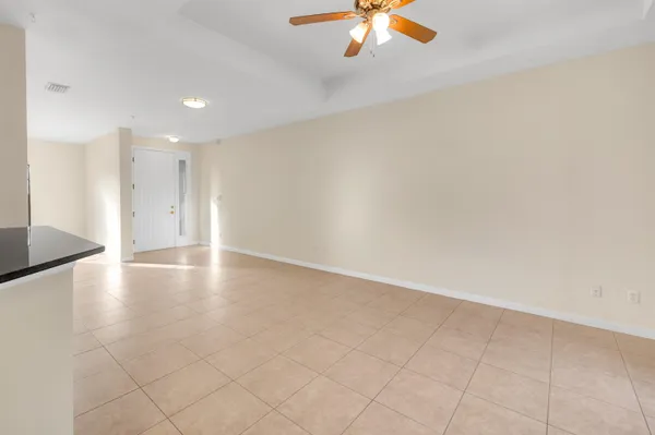 an empty room with wooden floor and chandelier