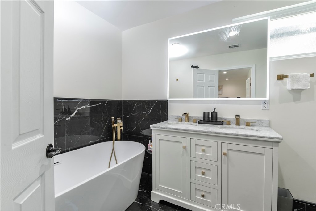 9728 Rhea Avenue Northridge, CA 91324 - Photo 25 of 36 a bathroom with a bathtub sink vanity and mirror