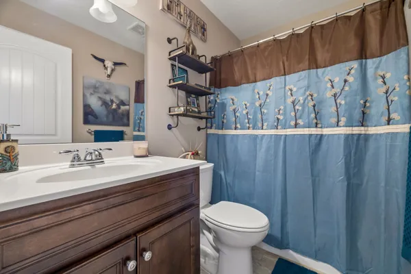 a bathroom with a granite countertop sink a toilet and a mirror