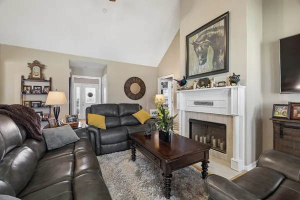 a living room with furniture kitchen view and a window