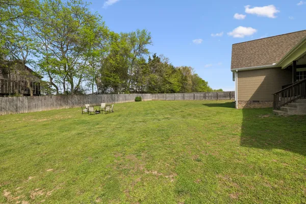 a view of an house with backyard and a tree