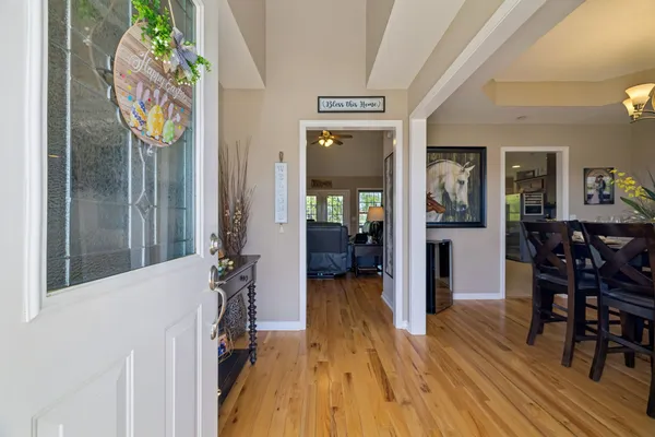 a view of a hallway with wooden floor and dining room