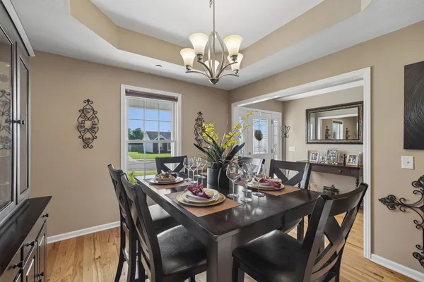 a view of a dining room with furniture a chandelier and wooden floor