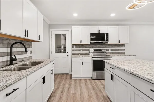 a kitchen with white cabinets and appliances