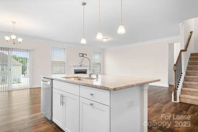 a kitchen with granite countertop a sink a counter space and wooden floor