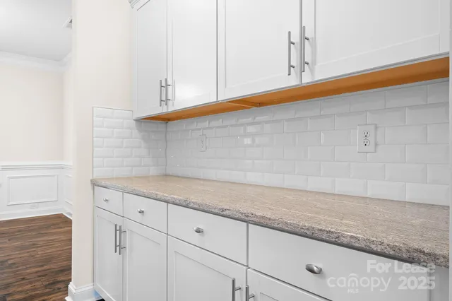 a kitchen with granite countertop white cabinets and sink