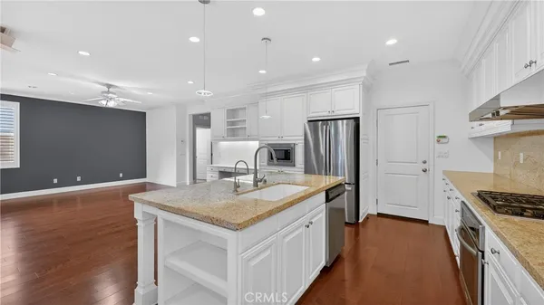 a kitchen with granite countertop a sink stove and cabinets