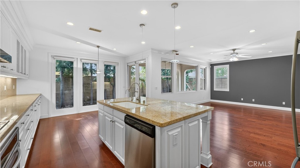 30 Maple Leaf Irvine, CA 92618 - Photo 9 of 19 a hall with kitchen island a stove a wooden floor and a large window