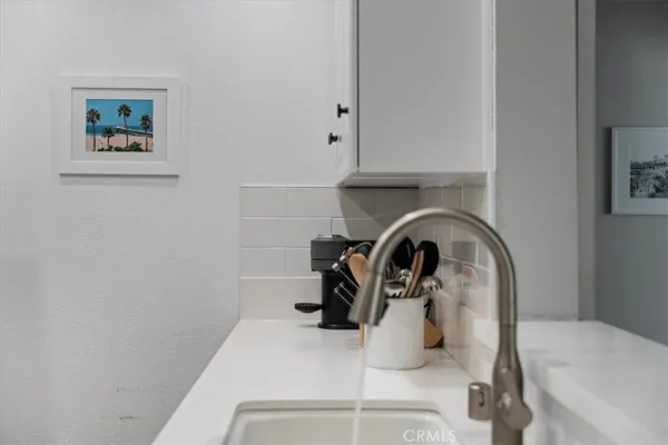 a kitchen with a sink a refrigerator and cabinets