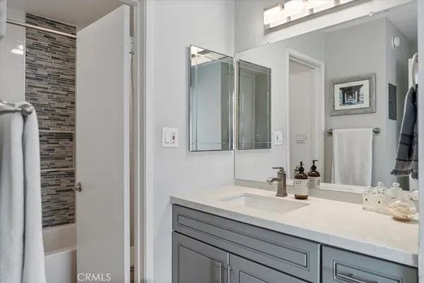 a bathroom with a tub sink and mirror