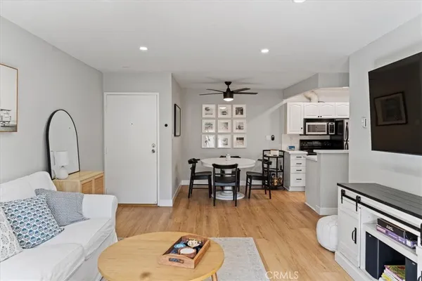 a living room with furniture a flat screen tv and kitchen view