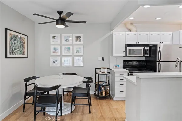 a kitchen with stainless steel appliances a table chairs and a refrigerator
