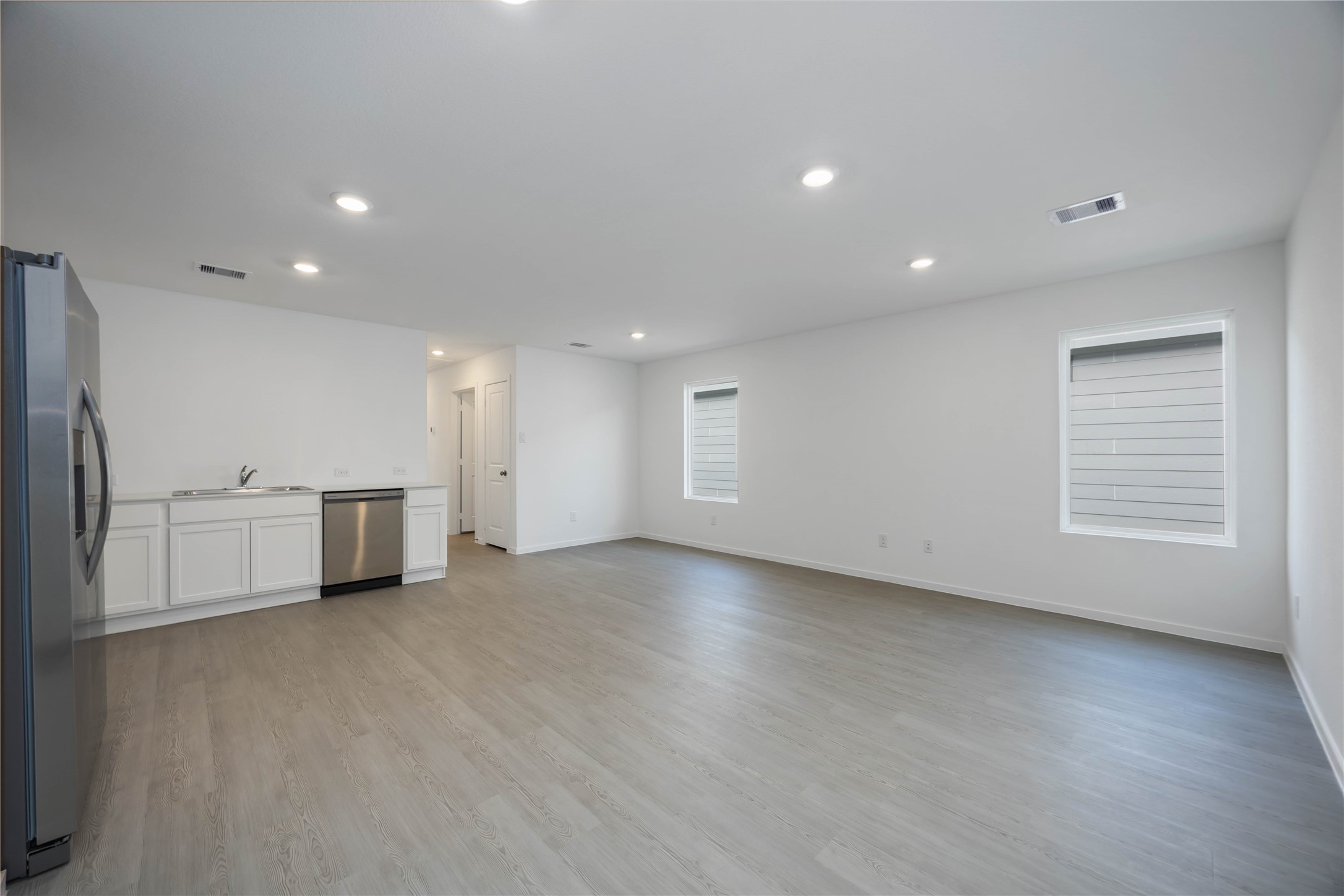 385 Lucia Way Cleveland, TX 77327 - Photo 8 of 30 an empty room with wooden floor and windows