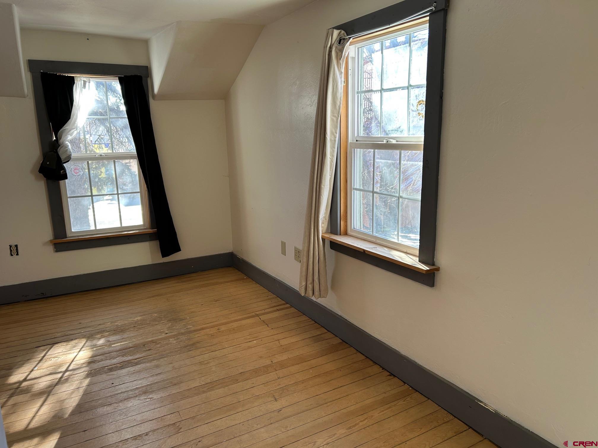318 East Main Street Cortez, CO 81321 - Photo 17 of 27 an empty room with wooden floor and windows