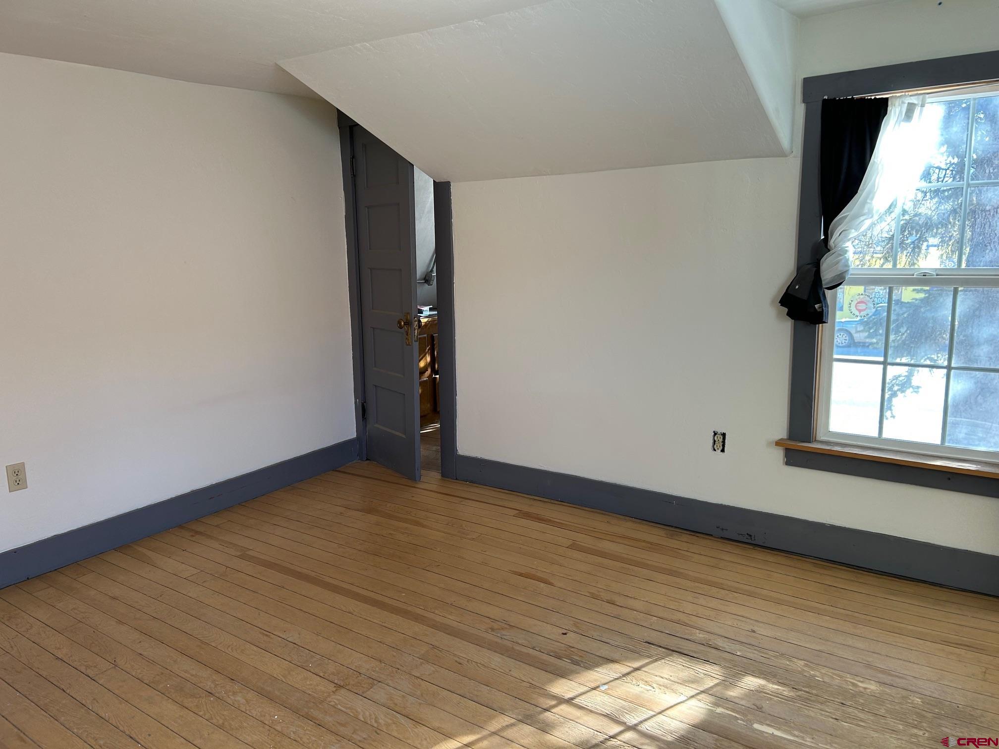318 East Main Street Cortez, CO 81321 - Photo 20 of 27 a view of an empty room with wooden floor and a window
