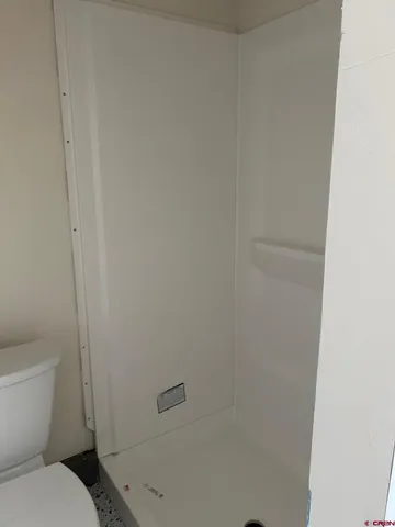 a white toilet sitting next to a shower