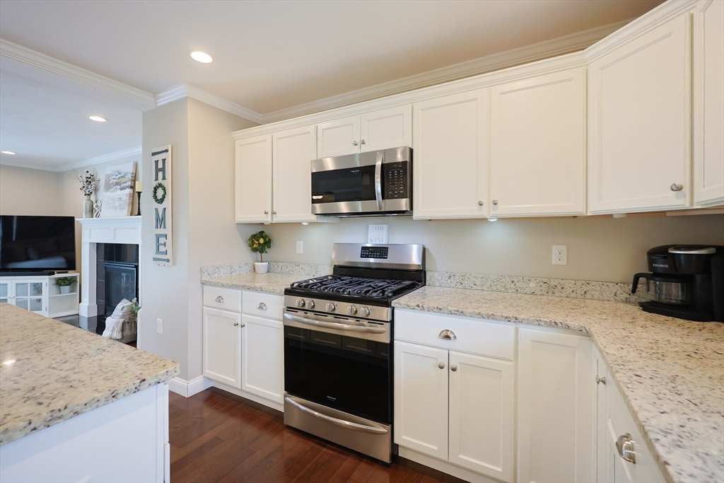 5 Mendon Road, Unit D Attleboro, MA 02703 - Photo 11 of 38 a kitchen with granite countertop a stove a sink and a microwave