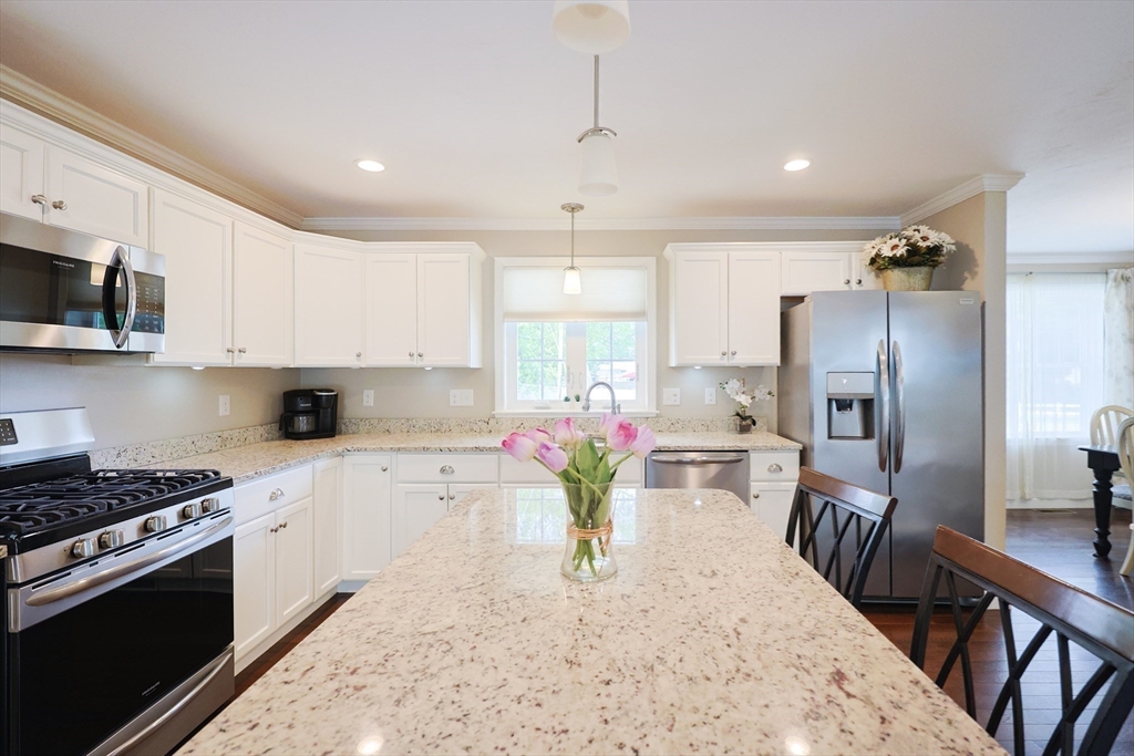 5 Mendon Road, Unit D Attleboro, MA 02703 - Photo 12 of 38 a kitchen with stainless steel appliances kitchen island granite countertop a stove refrigerator sink and microwave