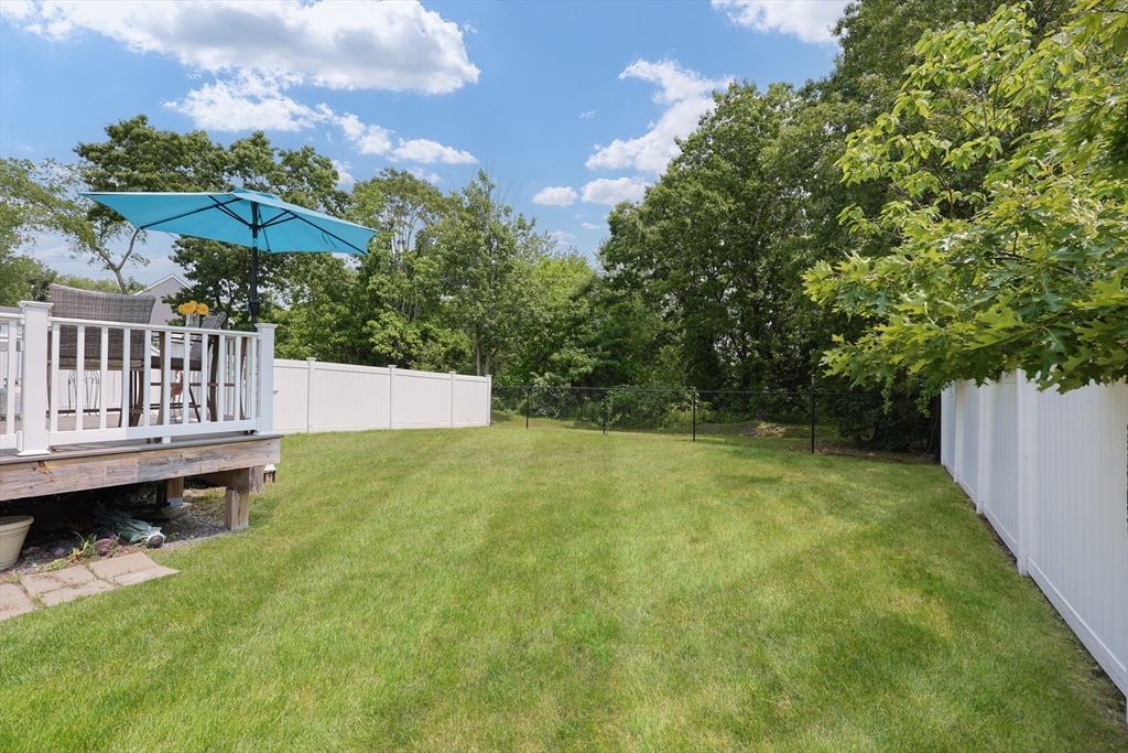 5 Mendon Road, Unit D Attleboro, MA 02703 - Photo 36 of 38 a view of a backyard with a small deck and a garden