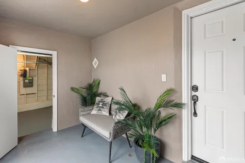 a living room with furniture and a potted plant on a dresser