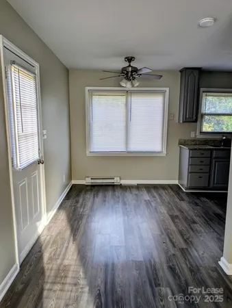 a view of a livingroom with wooden floor and a ceiling fan