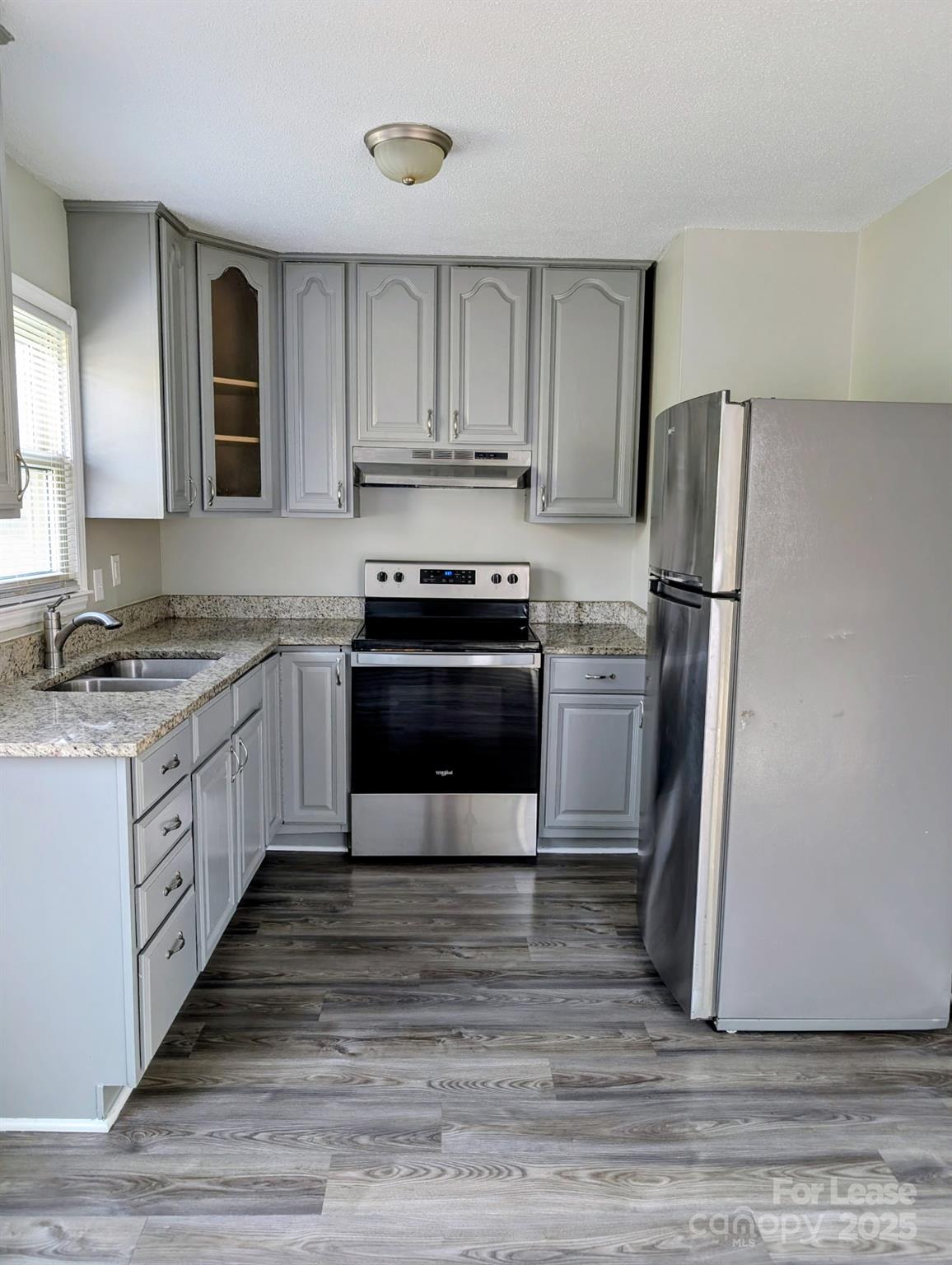 216 Lakeside Avenue Davidson, NC 28036 - Photo 9 of 10 a kitchen with granite countertop a refrigerator stove top oven and cabinets
