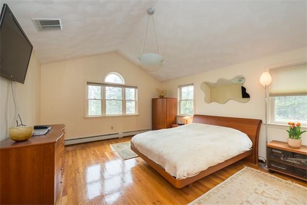 1 4th Street Lexington, MA 02420 - Photo 13 of 22 a bedroom with a bed table and flat screen tv