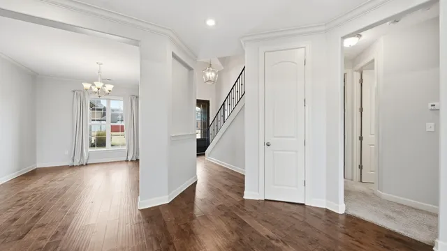 a view of a big room with wooden floor and a kitchen