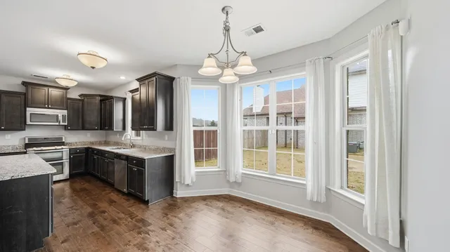 a view of a livingroom with a fireplace a ceiling fan and wooden floor