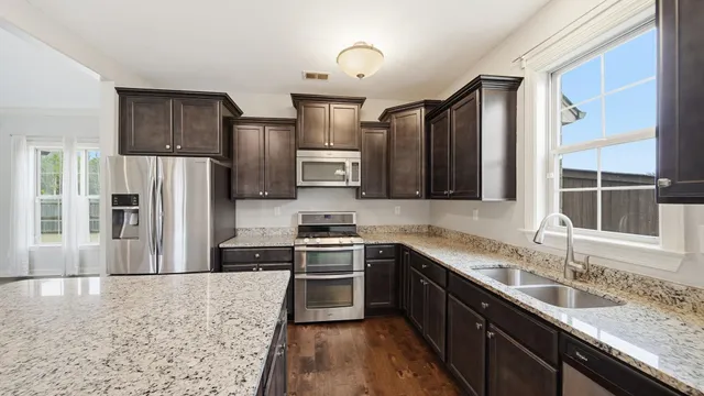 a kitchen with granite countertop a stove and a sink