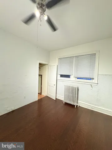 an empty room with a ceiling fan and windows