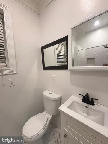 a bathroom with a toilet a sink and mirror