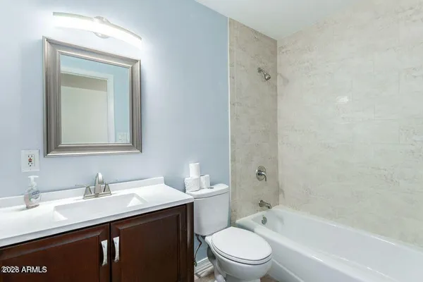 a bathroom with a granite countertop sink toilet a mirror and shower