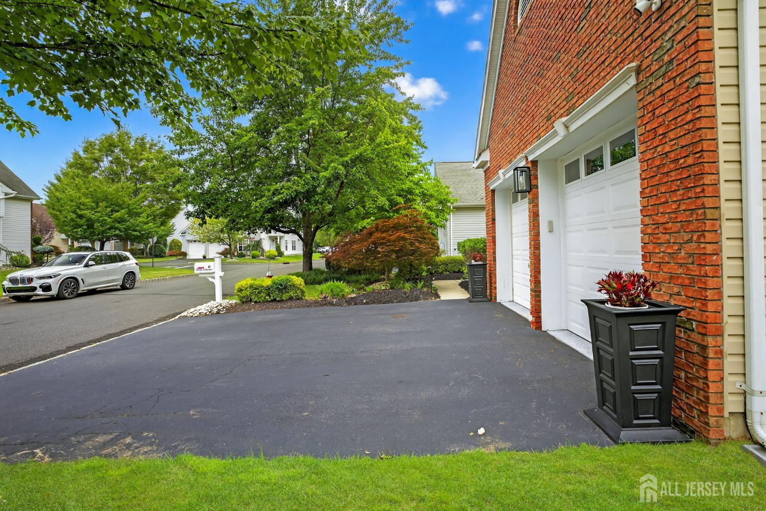 6 George Russell Way Clifton, NJ 07013 - Photo 44 of 45 a car parked in front of a house and a yard with potted plants