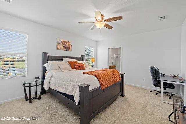 a bedroom with a bed a chair and a chandelier
