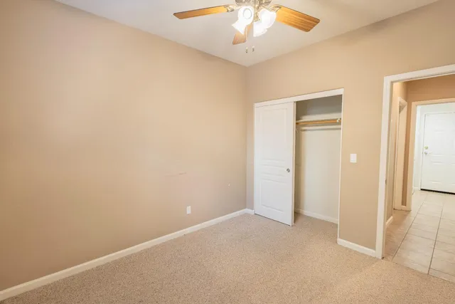 an empty room with a chandelier fan