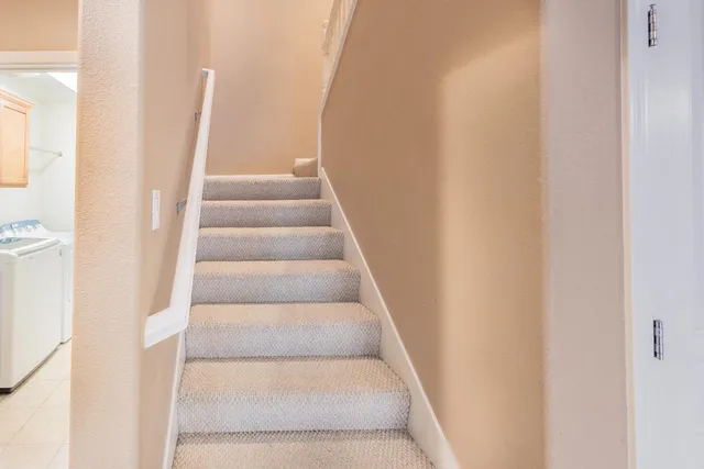 a view of staircase with white walls and white door