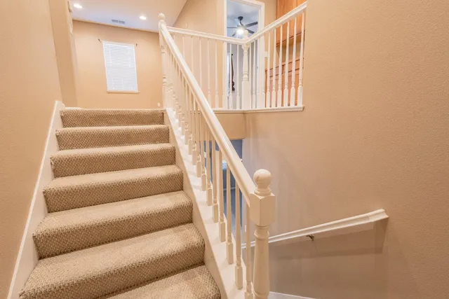 a view of staircase with wooden floor and white walls