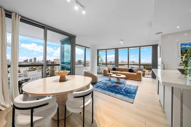 a living room with dining table and a large window