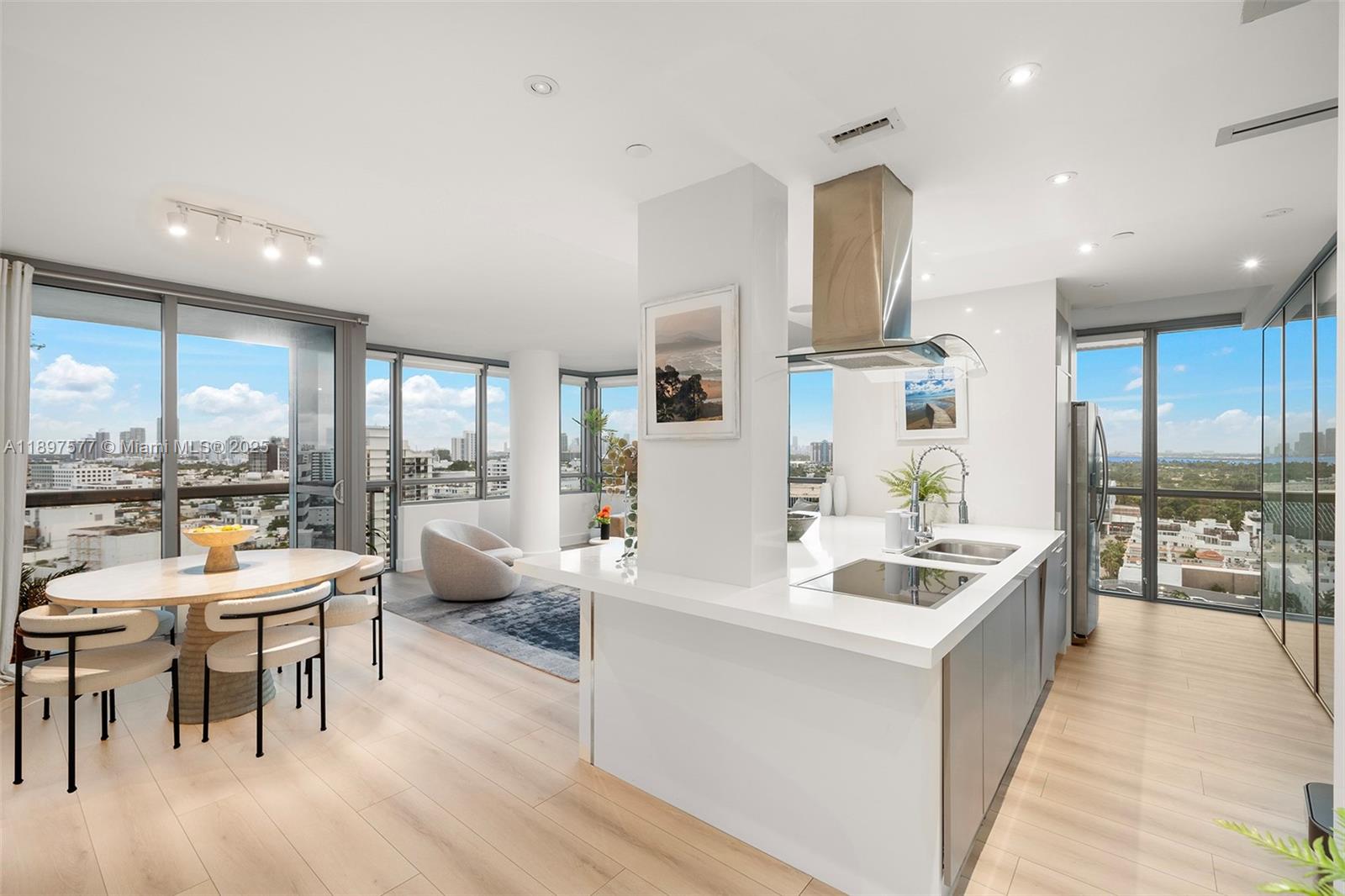 101 20th Street, Unit 2002 Miami Beach, FL 33139 - Photo 14 of 40 a large dining hall with stainless steel appliances kitchen island granite countertop a refrigerator a sink a stove and a dining table with wooden floor